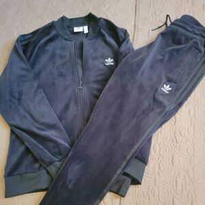 A womens Adidas tracksuit it's Black velour the jacket is a L and pants are a M.